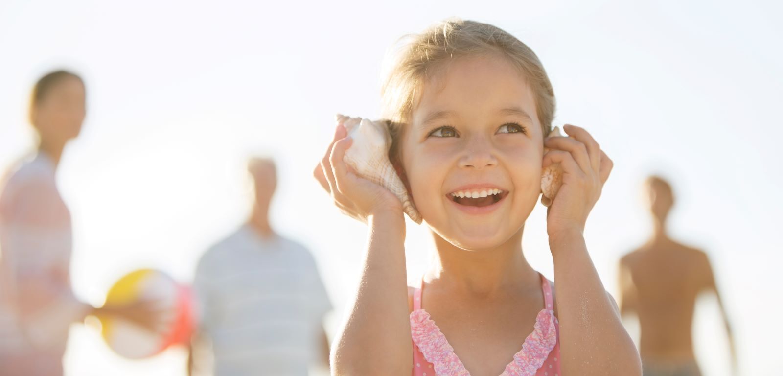 girl listening to sounds from seashell