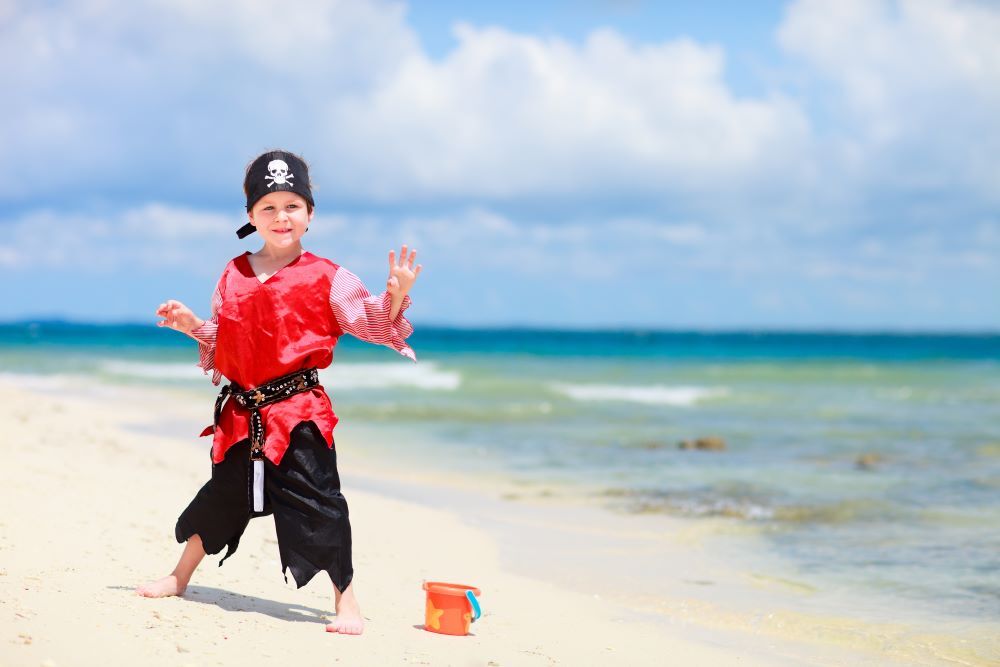 boy on beach in pirate costume