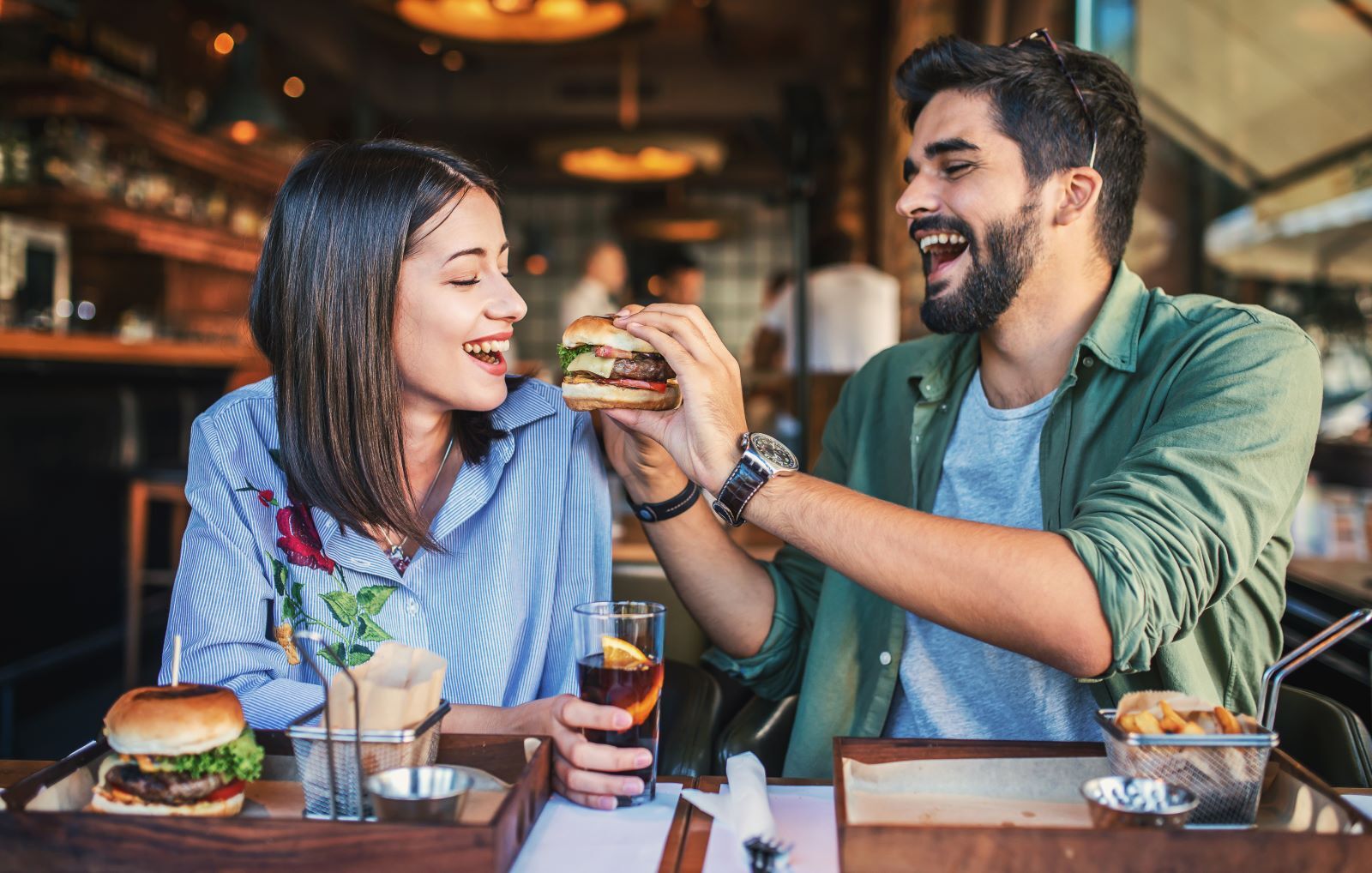couple eating a burger in restaurant